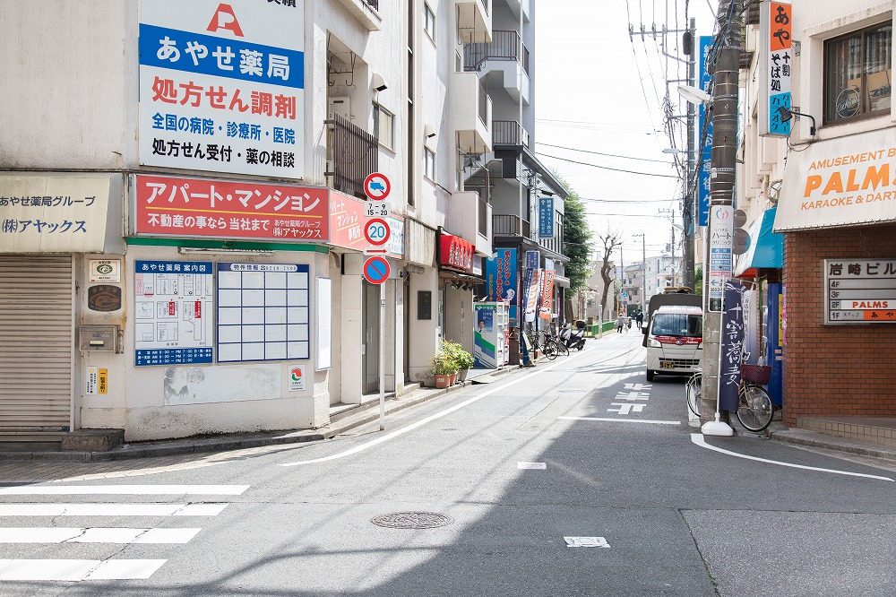 4.まっすぐ進むと1Fが不動産屋さんの、薬局さんの看板がある建物が見えてきます。